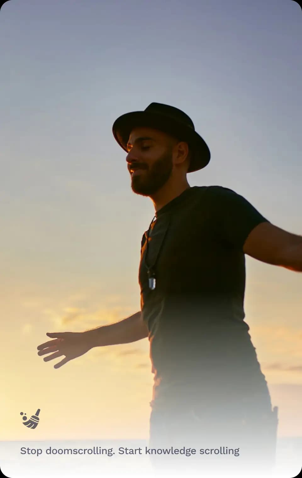 Man standing with open arms at sunset